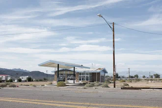 Photo art by Roman Becker: serene gas station in the desert with soft colors