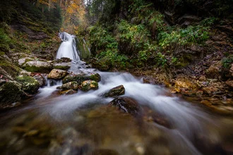 Waterfall in Bavaria: serene long exposure in autumn with colorful leaves.