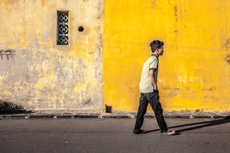 Fotokunst von Jörg Faißt: Junge spielt mit Schatten an einer gelben Wand in Vietnam.