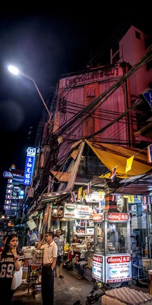 Night photo of Bangkok featuring bright lights in Chinatown and lively people.