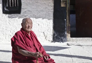 Smiling monk at Sera Monastery, embodying tranquility and spirituality in a peaceful setting.