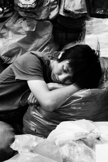 Sleeping vegetable vendor at Chatuchak Market, Bangkok, in black and white.