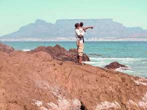 Photo art by Jessica Barnewitz: Father points to Table Mountain with his son in Cape Town.