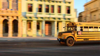Photo art by Tillmann Konrad: School bus passing by Malecón in Havana during sunset.