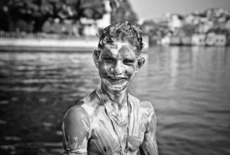 Photo art by Victoria Knobloch: smiling Indian boy at Pichola Lake, covered in soap.