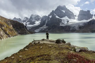Photo art by Sher Ali: Traveler in the Neelum Valley landscape with snow-covered mountains.