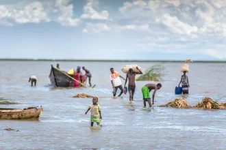 Fotokunst von Miro May: Rückkehr nach Hause in Kenia, Kinder und Boot am See.