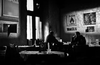 Fotokunst von Victoria Knobloch: Mann unterhält sich in einem gemütlichen Café in Krakau.