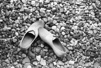 Simple photo art featuring white shoes on stones, soft black and white tones.