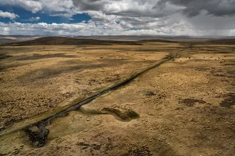 Photo art by Oliver Ostermeyer: serene landscape in Tibet with gentle hills.