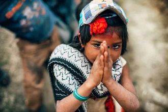 Portrait of a girl from Nepal warmly greeting with 'Namaste'.