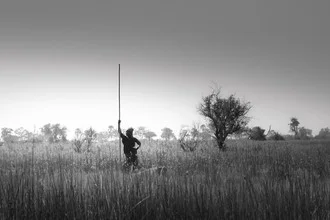Photo art by Tillmann Konrad: Fisherman in the Okavango with calm water surface.