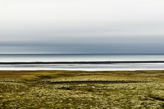 Abstract coast with gentle waves and a clear sky above the sea.