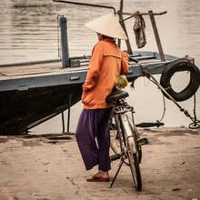Porträt eines Mannes auf einem Boot am Fluss in Vietnam, ruhige Atmosphäre.