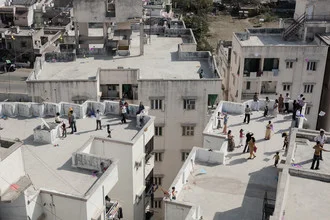 Families enjoy the sun on rooftops during the kite festival in Ahmedabad.