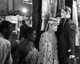 Wall art by Jagdev Singh: vibrant market scene with males and an effigy