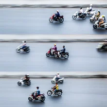 Photo art by Jörg Faißt: moped riders on a busy street in Hanoi