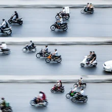 Photo art by Jörg Faißt: Moped riders in a vibrant traffic scene in Hanoi.