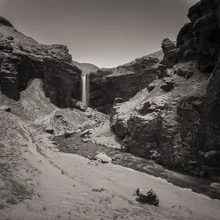 Fotokunst: sepiafarbener Wasserfall am Sólheimajökull in ruhiger Naturumgebung.