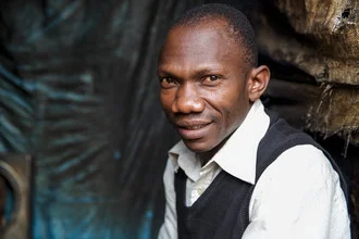 Portrait of a smiling man from Nairobi with intense eye contact.