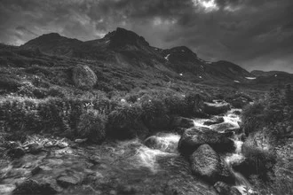 Photo art: serene river in the mountains, black and white, gentle waves and rocks