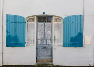 Photo art by Friedemann Baader: a charming house entrance with shutters and an angel.