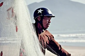 Photo art by Thomas Junklewitz: fisherman with a net by the sea in Vietnam