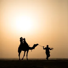 Photo art by Sebastian Rost: Silhouette of a camel caravan at sunset in the Thar Desert.