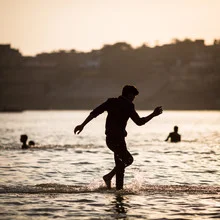Junge im Ganges, Silhouette gegen Sonnenuntergang, ruhige Stimmung am heiligen Fluss