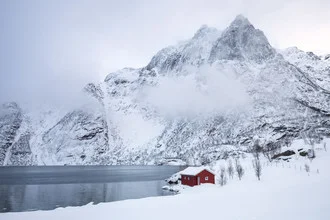Winter landscape featuring a frozen lake and snow-covered mountains, calm atmosphere