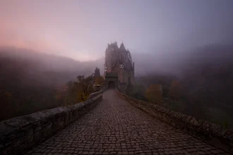 Misty Eltz Castle in the morning fog, featuring soft lighting and a calm atmosphere.