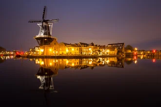 Fotografie einer Windmühle mit spiegelndem Wasser in der Abenddämmerung