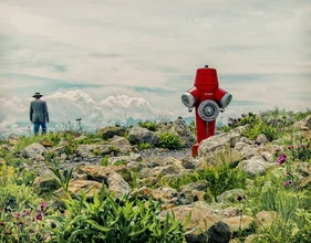 Fotokunst von Ambra A: ein Mann steht vor grünen Bergen unter einem blauen Himmel.