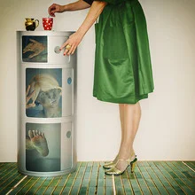 Fotokunst von Ambra A: Frau in grünem Kleid mit Kaffeetasse, umgeben von kleinen Geistern.