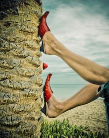 Photo art by Ambra A: A red shoe on a tree trunk at the beach in Tunisia.