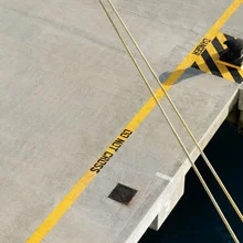 Rope at a pier in the Virgin Islands, surrounded by yellow lines and shapes.
