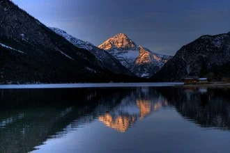 Fotokunst von Björn Groß: Morgenstimmung am Plansee mit sanften Sonnenstrahlen.