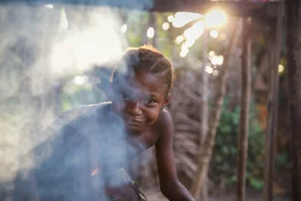Fotokunst von Miro May: Mädchen mit lächelndem Gesicht im Abendlicht von Sierra Leone.