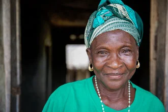 Photo art by Miro May: Smiling woman from Sierra Leone in traditional attire