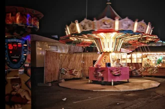 Fotokunst von Katja Diehl: Kinder verlassen einen bunten Rummel bei Nacht.