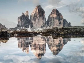 Fotokunst von Dominic Lars: ruhiger Bergsee mit Spiegelung der Dreizinnen bei Sonnenaufgang