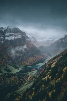 Herbstliche Alpenlandschaft mit Nebel über den Bergen und einem ruhigen See