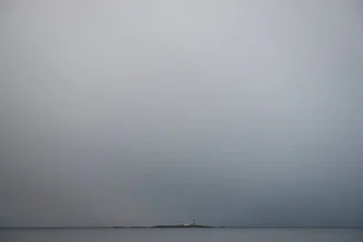 Fotokunst von Lars Jacobsen: Leuchtturm an stürmischem Meer in Norwegen