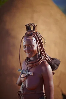 Portrait of a Himba woman in the Namibian desert, warm light and soft colors.
