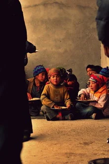 Photo art by Julia Hafenscher: Students enjoy their meal in a classroom in Nepal.