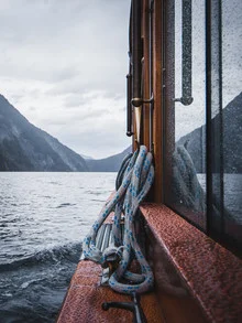 Photo art: boat ride on a calm lake with a reflecting sky and gentle clouds