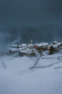 Swiss village in a snowstorm, serene winter landscape with snow-covered roofs.