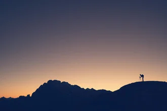 Silhouette of a photographer in the Italian Alps at dawn.