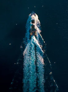 Aerial view of a boat racing through the water, with soft light and a dynamic atmosphere.