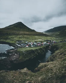 Photo art by Dorian Baumann: coastal town in the Faroe Islands with mountains and clouds